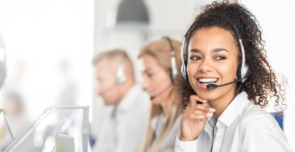 A female contact centre agent smiling with her headphones on