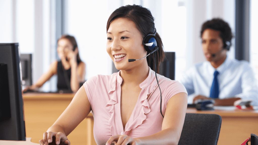 A call centre agent with headphones on, handling a customer call