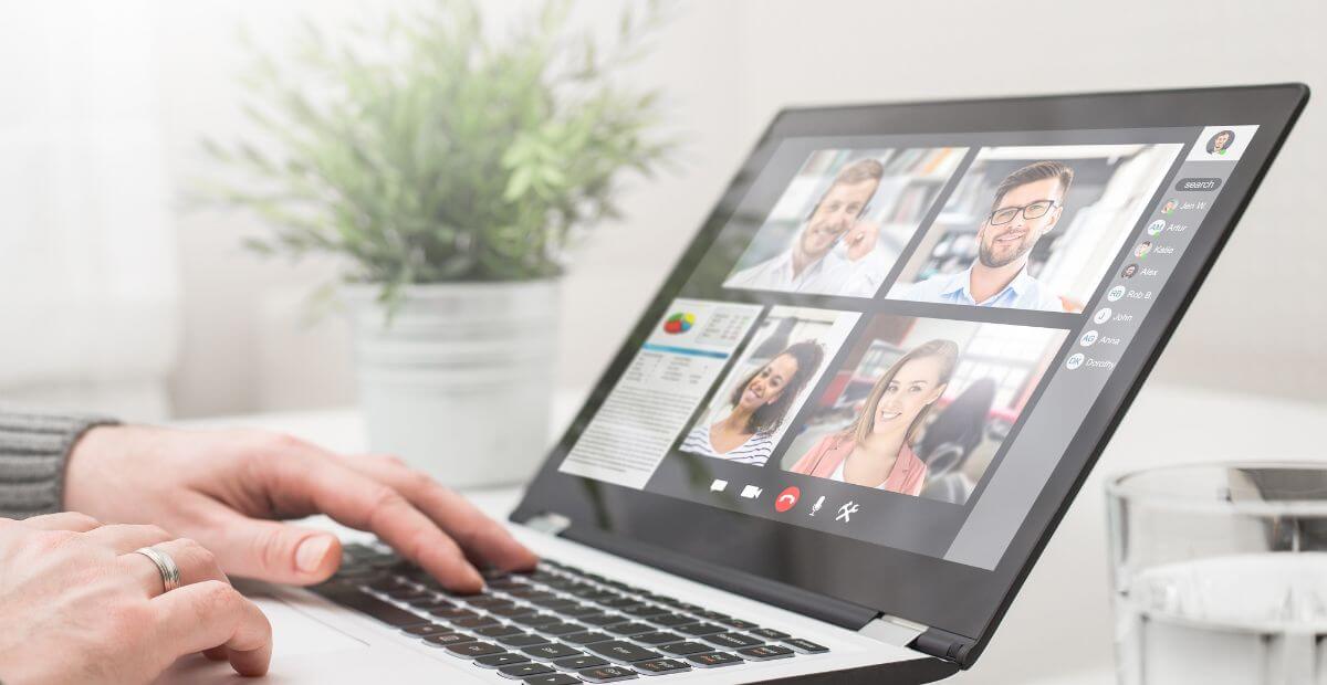 A man on a video call on his laptop - video conferencing apps vs. audio conferencing apps - what the difference and why bother?