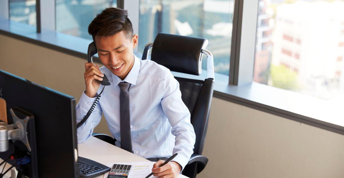 Advantages of audio conferencing - a photo of a business professional on his desk while talking on the phone