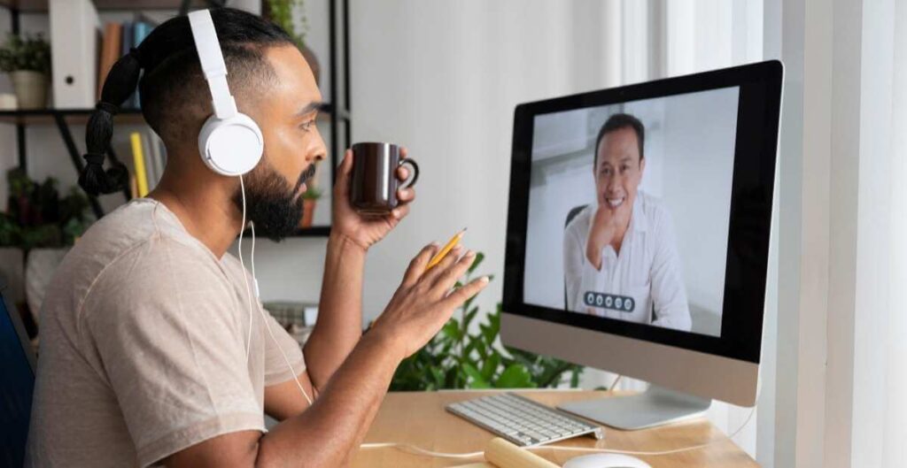 BlueJeans - video conferencing for remote work - a man talking to a colleague via a video meeting on his computer