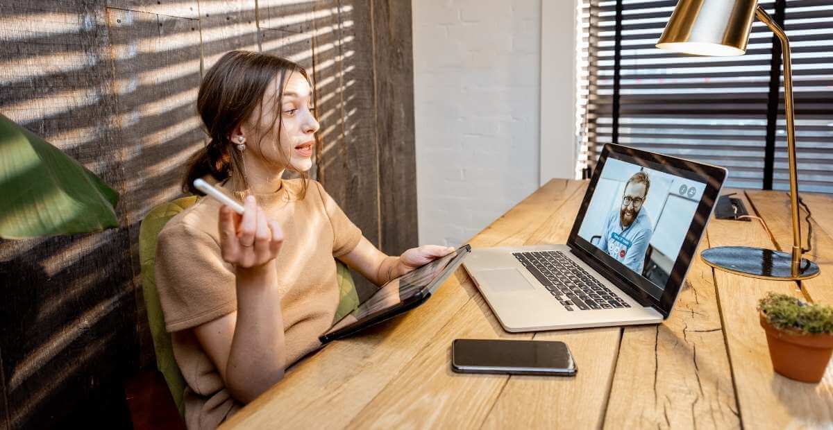 Zoom - video meeting app - a photo showing a lady on a video call with a man on her laptop screen