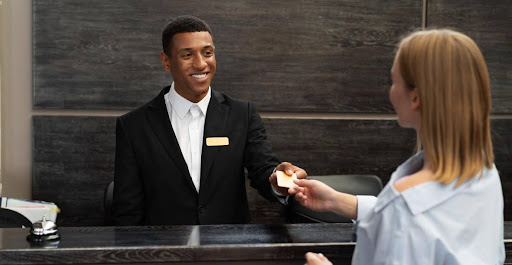 Stage 3: Connecting with customers on arrival | A female customer taking a key from a hotel receptionist