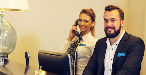 The role of contact centres in advancing the hotel guest experience | A male and female contact agents at a hotel's reception