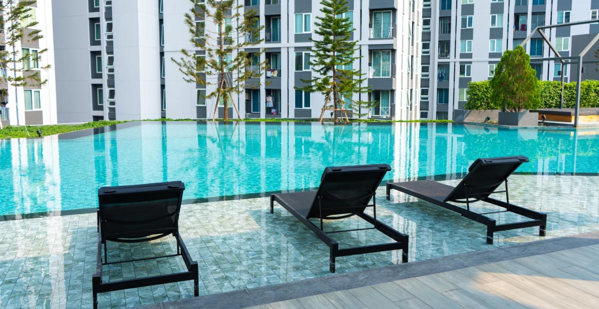 Facility amenities | A hotel poolside with resting chairs
